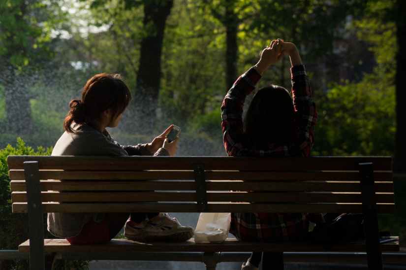 bench people smartphone sun